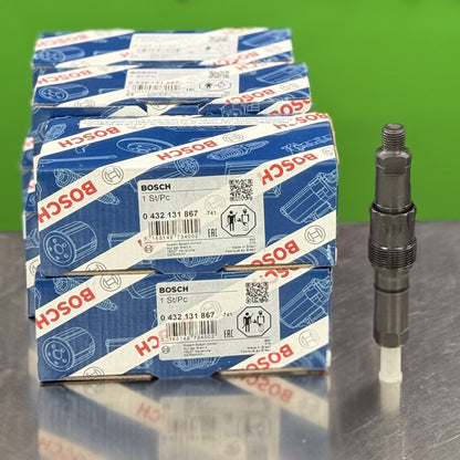 Stack of Bosch branded boxes with a spark plug on a reflective surface and green background