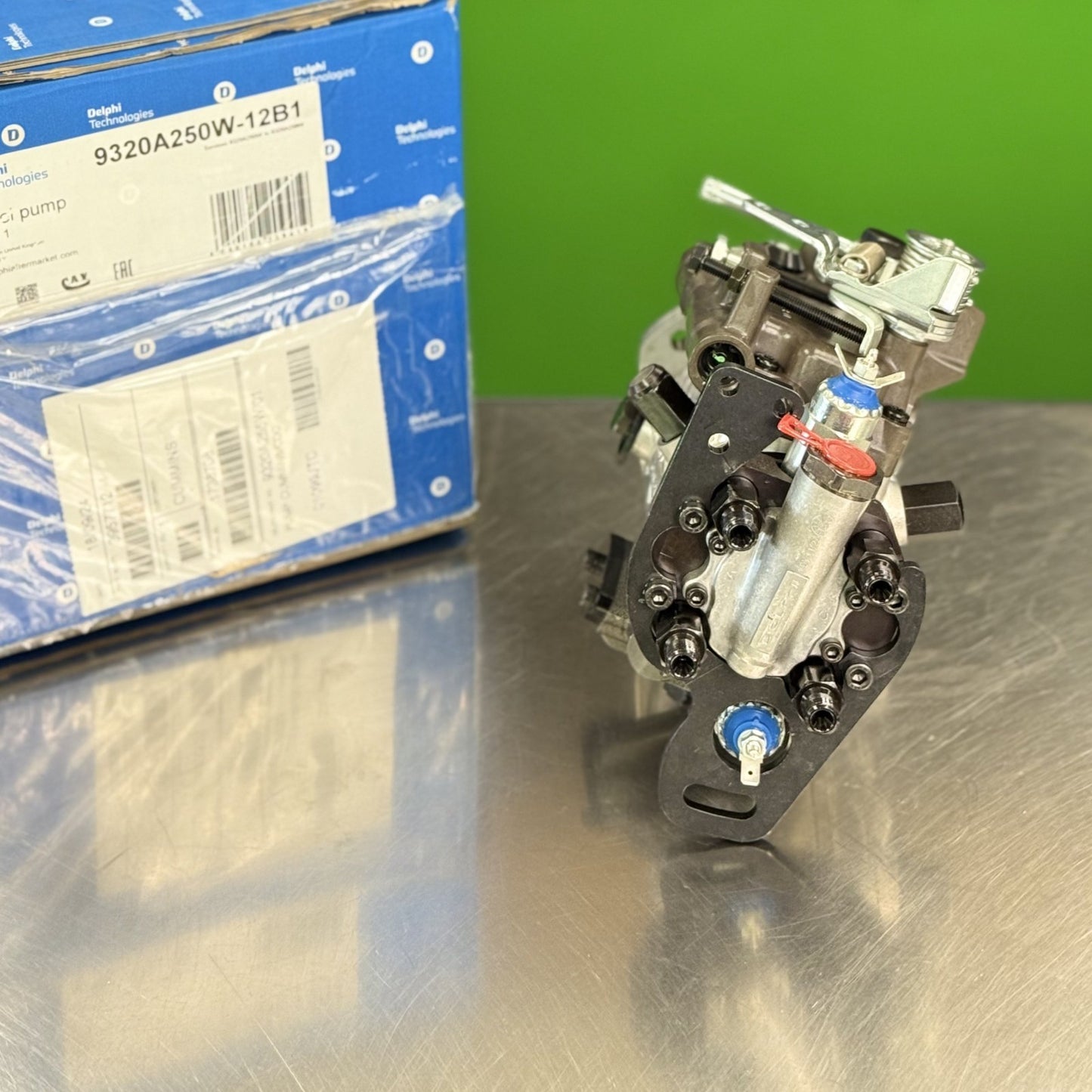 Delphi 9320A250W fuel injection pump showing fuel line outlet connections and linkage detail