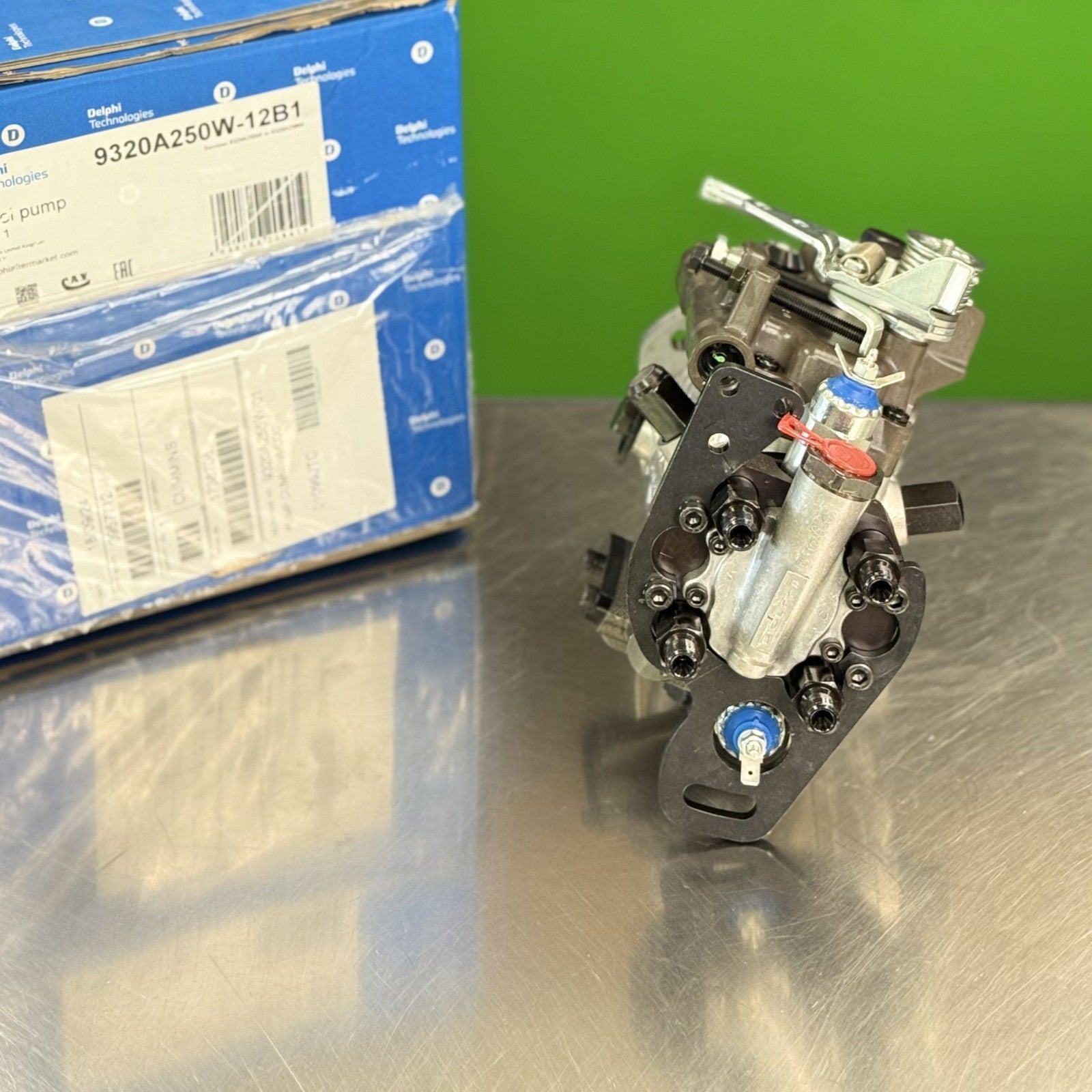 Delphi 9320A250W fuel injection pump showing fuel line outlet connections and linkage detail