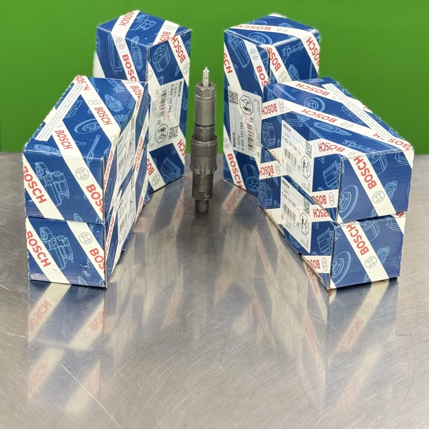 Bosch spark plug and multiple boxes stacked on a reflective surface with a green background