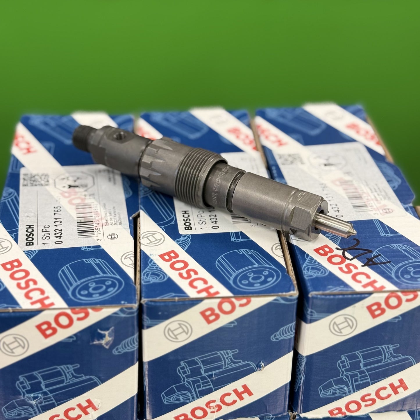 Bosch fuel injector on top of Bosch boxes with a green background