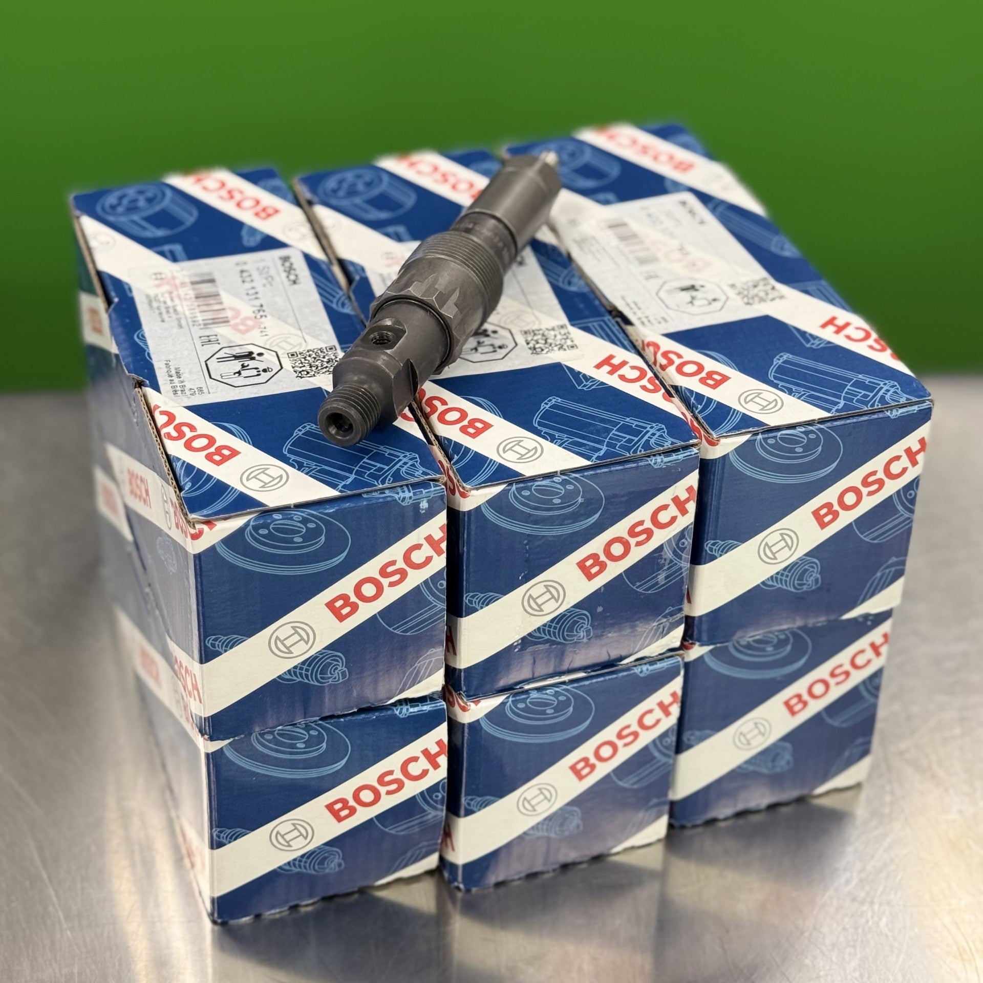 Bosch branded boxes stacked with a spark plug on a reflective surface.